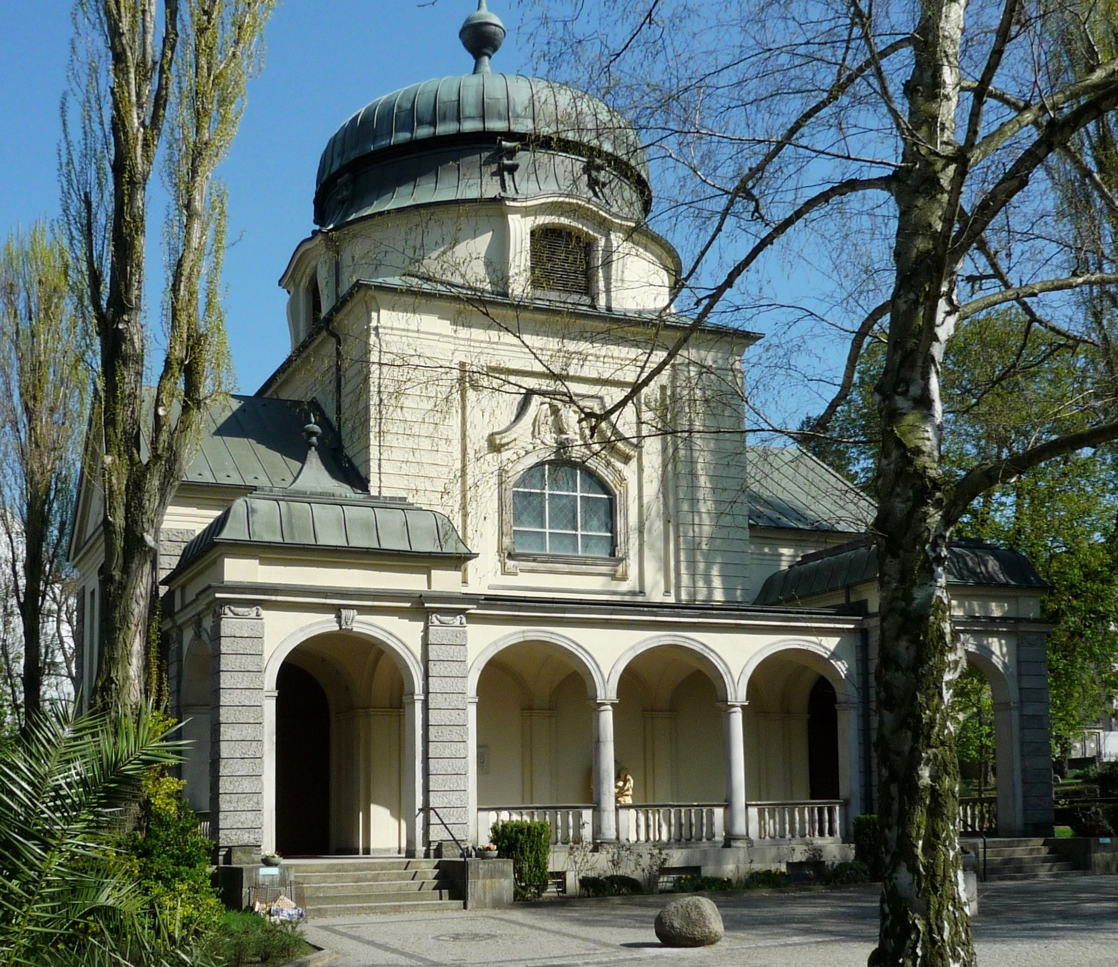 Friedhofskapelle des Alten St.-Matthäus-Kirchhofs zwischen Bäumen und Grabstätten